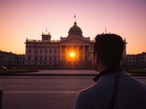 O siluetă în fața Parlamentului României, la apus.